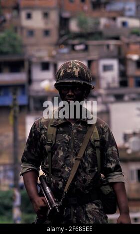 Militärische Person Bekämpfung der städtischen Gewalt in Rio de Janeiro Favela. Besetzung von benachteiligten Gebieten durch die Armee als Teil der Regierungspolitik für öffentliche Sicherheit in Vorbereitung auf die Fußball-Weltmeisterschaft 2014 in Brasilien. Stockfoto