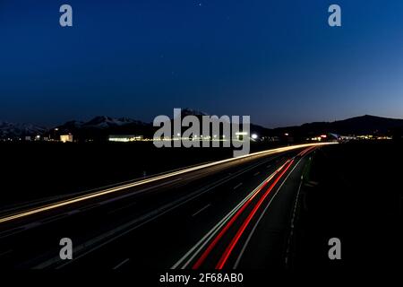 Langzeitaufnahme einer Autobahn mit Lichtspur, aufgenommen in der Nähe von Bulle, Freiburg, Schweiz Stockfoto