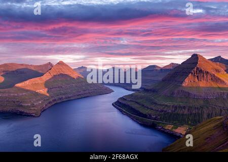 Unglaublicher violetter Sonnenuntergang über den majestätischen Fjorden von Funningur Stockfoto