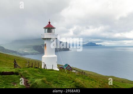 Nebliger Blick auf den alten Leuchtturm auf der Insel Mykines Stockfoto