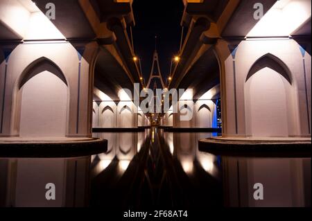 Wunderschöne Aussicht auf die berühmte blau beleuchtete Al Garhoud Brücke in Dubai, Vereinigte Arabische Emirate mit den bunten Spiegelungen auf dem Wasser Stockfoto