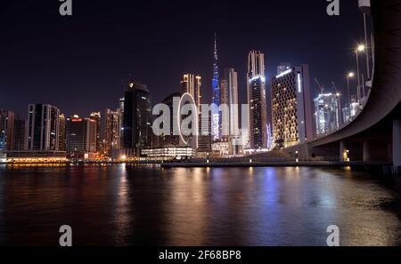 Wunderschöne Aussicht auf die beleuchteten Himmelsschrapper und den Burj khalifa, aufgenommen von der Marasi Drive im Business Bay District, Dubai, VAE. Stockfoto