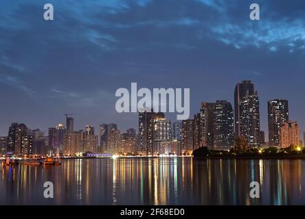 Panoramablick auf die Wolkenkratzer von Sharjah, aufgenommen vom Majaaz Park , Sharjah, VAE Langzeitbelichtung Nachtfotografie im Sharjah Winter. Stockfoto