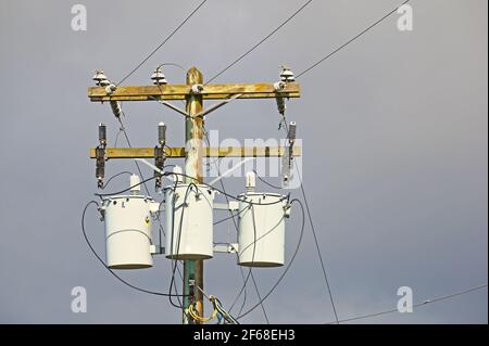 Stromleitungen und Transformatoren gegen einen stürmischen Himmel. Stock Foto. Stockfoto