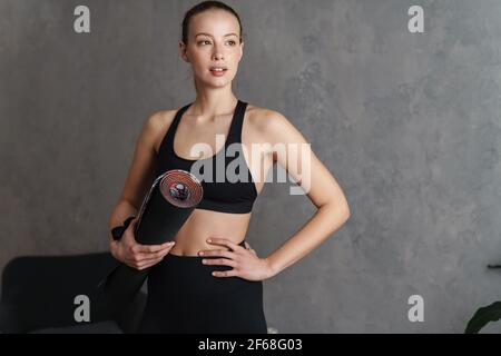 Lächelnde Fitness Frau in einem Fitness-Studio mit einem Yogamatte Stockfoto