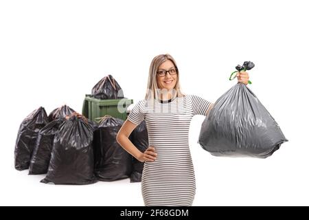 Junge Frau wirft einen Müllbeutel in einen isolierten Papierkorb Auf weißem Hintergrund Stockfoto