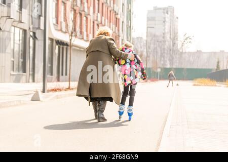 Großmutter lehrt Enkelin Rollschuh Stockfoto