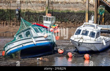 Zwei kleine Fischerboote, die am 30. März 2021 bei Flut im Hafen von West Bay, Dorset, Großbritannien, angelocht wurden Stockfoto