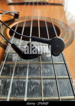 Akustische Gitarre und Kopfhörer. Gitarre im Retro-Stil und Kopfhörer. Stockfoto