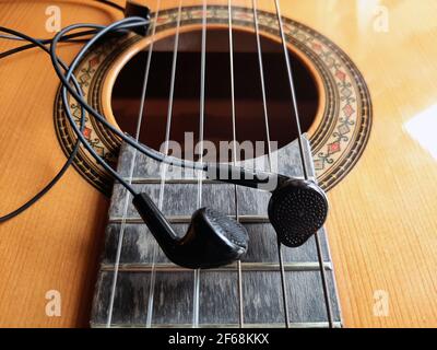 Akustische Gitarre und Kopfhörer. Gitarre im Retro-Stil und Kopfhörer. Stockfoto