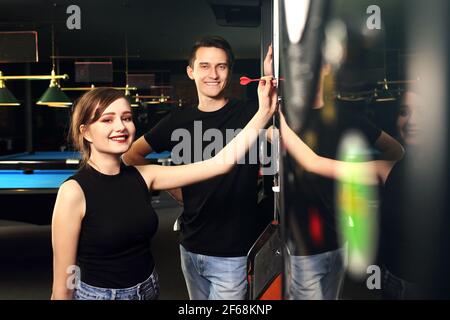 Darts. Junge Menschen werfen Darts auf das Ziel. Freundliches Spiel in einem Pub. Stockfoto