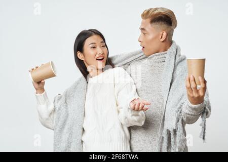 Junge asiatische paar mit karierten wärmenden Getränk Mode Stockfoto