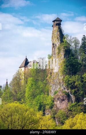 oravsky podzamok, slowakei - 01. MAI 2019: Burgturm auf dem Felsen. Schöne sonnige Landschaft im Frühling. Bäume in grünem Laub auf der Wiese ben Stockfoto