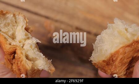 Zerreißen Sie ein frisch gebackenes Croissant in Zeitlupe Stockfoto