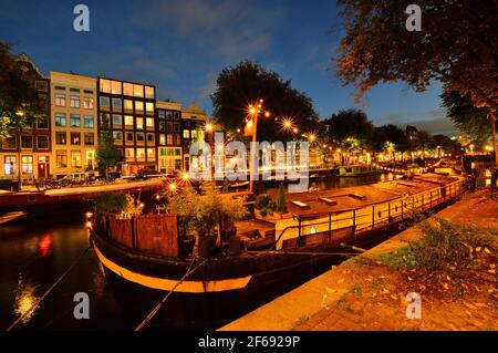 Hausboot auf dem Kanal in Amsterdam bei Nacht. Farbenfroh. Stockfoto