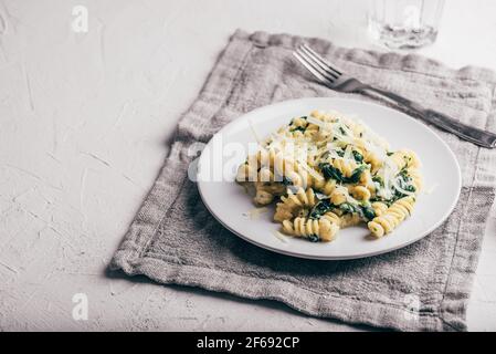 Cremige Spinat Pasta mit Ricotta und Parmesan auf weißem Teller Stockfoto