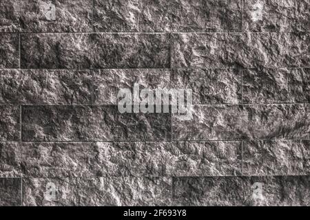 Schwarze und weiße Steinwand Textur, abstrakte dekorative Ziegelsteine, monochrome Fliese mit einem Muster, grunge Hintergrund. Stockfoto