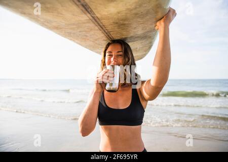 Frau genießt Morgenkaffee vor dem Surfen Stockfoto