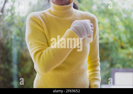 Hand der Frau mit gelben Pullover verbunden Stockfoto