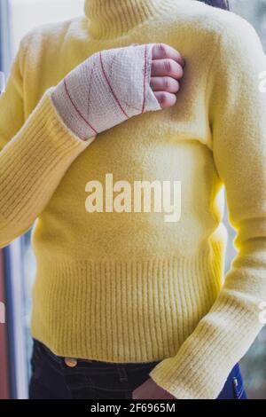 Hand der Frau mit gelben Pullover verbunden Stockfoto