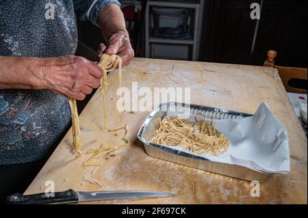 Oma arrangiert Nudeln auf der Aluminiumsohle Stockfoto