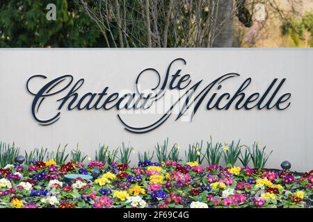 Eintrittsschild zum Weingut Chateau Ste Michelle in Woodinville Washington State mit dem Namen in Schrift und Frühlingsblumen Im Vordergrund Stockfoto