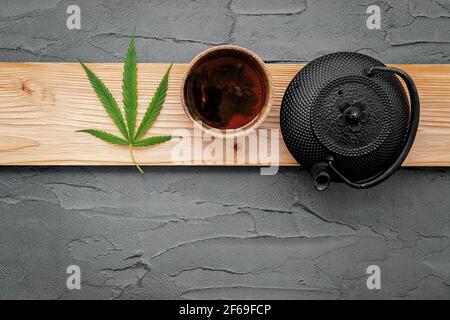 Vintage Teekanne mit Cannabis Kräutertee und frische Marihuana Blätter auf Beton Hintergrund gesetzt. Stockfoto