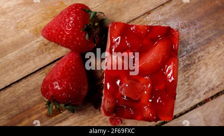 Ein köstliches Stück Erdbeerkuchen auf einem Holztisch Stockfoto