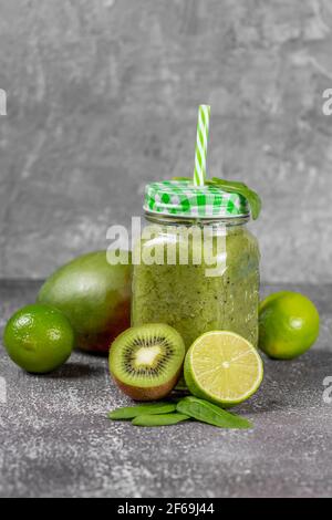 Frisch zubereiteter Smoothie aus grünem Obst und Gemüse auf grauem Betongrund. Das Konzept eines gesunden Lebensstils und der richtigen Ernährung. Gut für dich Stockfoto