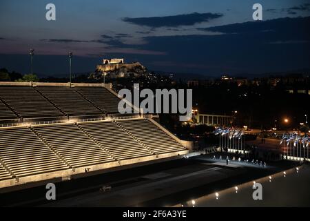 Athen. März 2021, 29th. Das Foto vom 29. März 2021 zeigt einen Teil des Panathenaic Stadions und der Akropolis von Athen im Hintergrund in Athen, Griechenland. Am Montagabend wurde ein neues Beleuchtungssystem im Athener Panathenaic-Stadion vorgestellt. Der Hauptort der ersten Olympischen Spiele 1896 in Marmor ist jetzt mit Tausenden von LED-Lampen beleuchtet, um die Lichtverschmutzung zu verringern und Energie zu sparen. Quelle: Lefteris Partsalis/Xinhua/Alamy Live News Stockfoto