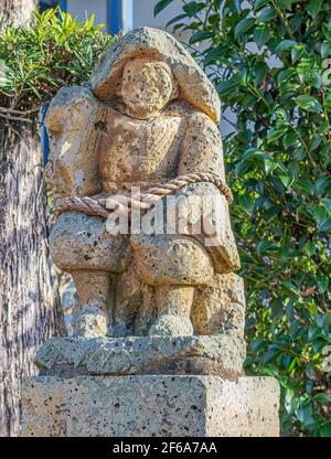 Eine alte und gesichtslose Statue eines sitzenden Samurai. Stockfoto