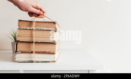 Hand hält einen Stapel von alten Büchern in der Bibliothek, Konzept des Lernens, Studium und Bildung, Konzept der Wissenschaft, Weisheit und Wissen. Hochwertige Pho Stockfoto