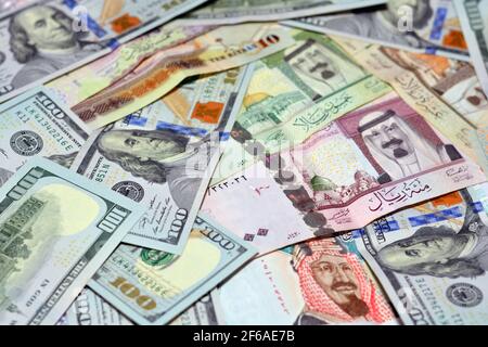 Saudi-Arabien Währung mit US-Dollar-Banknoten. Verschwommenes Geld. Saudi Geld und amerikanische Dollar Wechselkurs, 100 Dollar , verschiedene saudische Riyals Stockfoto