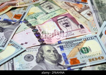 Saudi-Arabien Währung mit US-Dollar-Banknoten. Verschwommenes Geld. Saudi Geld und amerikanische Dollar Wechselkurs, 100 Dollar , verschiedene saudische Riyals Stockfoto