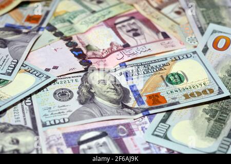 Saudi-Arabien Währung mit US-Dollar-Banknoten. Verschwommenes Geld. Saudi Geld und amerikanische Dollar Wechselkurs, 100 Dollar , verschiedene saudische Riyals Stockfoto