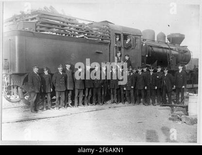 Bahnpersonal wurde vor einer Dampfsauna gesammelt, die Brennholz als Brennstoff hat. Stockfoto