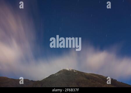 Langzeitbelichtung des Pichincha Vulkans mit Sternenspuren bei Nacht, Quito, Ecuador. Stockfoto