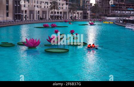 JANUAR 2021, DUBAI, VAE. TOURISTEN, DIE IM WUNDERSCHÖNEN LOTUS-POOL AUF DEM ERHOLUNGSBOULEVARD DES BURJ PARK, DUBAI, VAE, MIT BOOTEN FAHREN Stockfoto