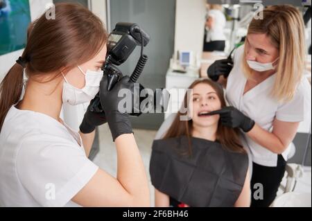 Zahnarzt, der in der Zahnarztpraxis ein Foto von einer Patientin gemacht hat. Stockfoto