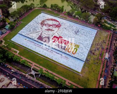 Menschen aus Barisal, einer Stadt von Bangladesch haben das größte menschengemachte Logo in mehr als 1, 60.000 Quadratfuß Feldfläche gemacht, um das Geburtsjahr 100th des Vaters der Nation zu feiern, “Bangabandhu, Sheikh Mujibur Rahman am 30th. März, 2021. Insgesamt 10.050 Plakat insgesamt 120 Zeilen, wobei jede Zeile aus 84-85 Plakaten besteht, werden verwendet, um das längste und größte von Menschen gemachte Logo zu machen. Mindestens 100-120 Arbeiter arbeiteten bis 12-13 Tage hart, um dieses riesige Logo zu machen und rund 10000 Menschen standen mit Plakaten in den Händen, um das Logo erfolgreich sichtbar zu machen. (Foto von Mustasinur Stockfoto