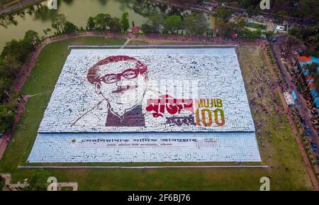 Menschen aus Barisal, einer Stadt von Bangladesch haben das größte menschengemachte Logo in mehr als 1, 60.000 Quadratfuß Feldfläche gemacht, um das Geburtsjahr 100th des Vaters der Nation zu feiern, “Bangabandhu, Sheikh Mujibur Rahman am 30th. März, 2021. Insgesamt 10.050 Plakat insgesamt 120 Zeilen, wobei jede Zeile aus 84-85 Plakaten besteht, werden verwendet, um das längste und größte von Menschen gemachte Logo zu machen. Mindestens 100-120 Arbeiter arbeiteten bis 12-13 Tage hart, um dieses riesige Logo zu machen und rund 10000 Menschen standen mit Plakaten in den Händen, um das Logo erfolgreich sichtbar zu machen. (Foto von Mustasinur Stockfoto