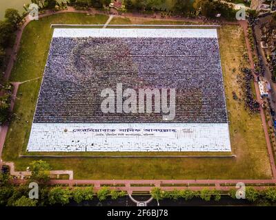 Menschen aus Barisal, einer Stadt von Bangladesch haben das größte menschengemachte Logo in mehr als 1, 60.000 Quadratfuß Feldfläche gemacht, um das Geburtsjahr 100th des Vaters der Nation zu feiern, “Bangabandhu, Sheikh Mujibur Rahman am 30th. März, 2021. Insgesamt 10.050 Plakat insgesamt 120 Zeilen, wobei jede Zeile aus 84-85 Plakaten besteht, werden verwendet, um das längste und größte von Menschen gemachte Logo zu machen. Mindestens 100-120 Arbeiter arbeiteten bis 12-13 Tage hart, um dieses riesige Logo zu machen und rund 10000 Menschen standen mit Plakaten in den Händen, um das Logo erfolgreich sichtbar zu machen. (Foto von Mustasinur Stockfoto