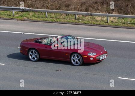 2004 04plate rotes Jaguar XKR Cabrio Auto 4196cc Benziner-Cabriolet; Fahrzeugverkehr, bewegliche Fahrzeuge, Autos, Fahrzeug fahren auf britischen Straßen, Motoren, Fahren auf der Autobahn M6 Englische Autobahn Straßennetz Stockfoto