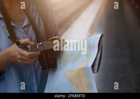 Bild von Young Freelance mit Kamera an den Händen am Bahnhof vor der Reise. Arbeits- und Reisekonzept. Stockfoto