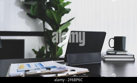 Tablet-Computer, Kaffeetasse und Dokumente auf dem Schreibtisch. Stockfoto