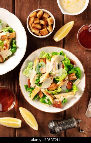 Caesar Salat ein rustikaler Holztisch mit Wein Stockfoto