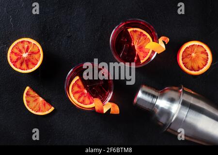 Negroni-Cocktails, darüber liegende flache Lay Shot mit Blutorangen und ein Shaker Stockfoto