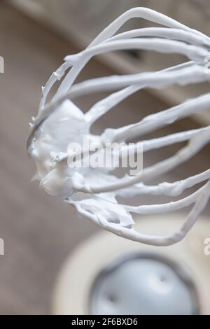 Schneebesen mit Schneebesen von Eiweiß und Zucker in einem Planetenmischer. Zutat für die Herstellung von Baiser oder Pavlova Dessert. Dessert backen Konzept. Auswahl Stockfoto