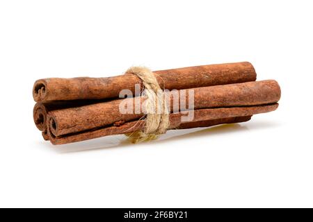 Zimtstangen mit Jute-Seil zum Kochen und Kosmetik gebunden. Nahaufnahme-Makro auf weißem Hintergrund mit Schatten isoliert. Volle Schärfentiefe, hohe Reso Stockfoto