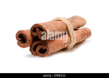 Zimtstangen mit Jute-Seil zum Kochen und Kosmetik gebunden. Nahaufnahme-Makro auf weißem Hintergrund mit Schatten isoliert. Volle Schärfentiefe, hohe Reso Stockfoto